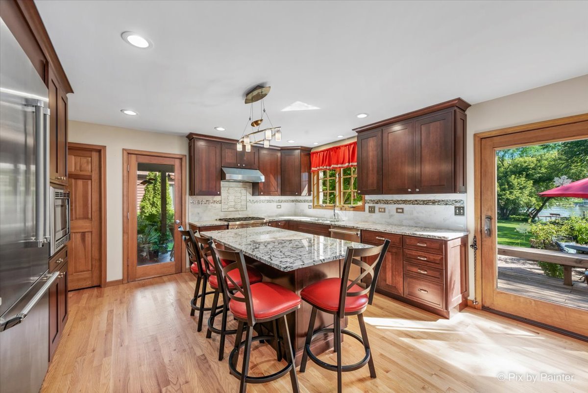 28683 Rivers Edge Drive Cary, IL 60013 - Photo 12 of 31 a kitchen with stainless steel appliances granite countertop a kitchen island hardwood floor sink stove dining table and chairs