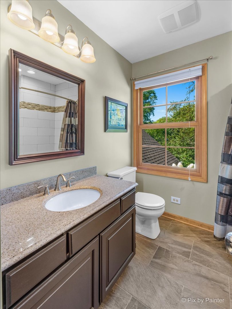 28683 Rivers Edge Drive Cary, IL 60013 - Photo 21 of 31 a bathroom with a granite countertop toilet a sink and a large mirror