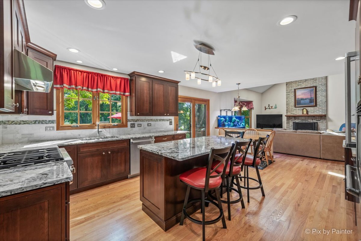 28683 Rivers Edge Drive Cary, IL 60013 - Photo 9 of 31 a kitchen with stainless steel appliances granite countertop wooden floors stove refrigerator and sink