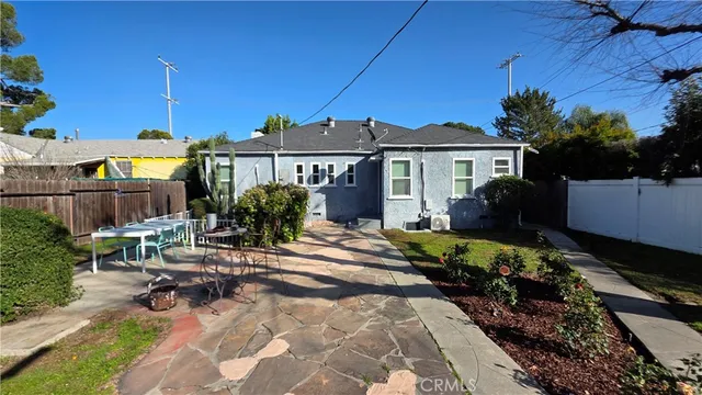 a view of a house with backyard sitting area and garden