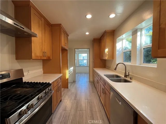a kitchen with stainless steel appliances a sink stove and cabinets