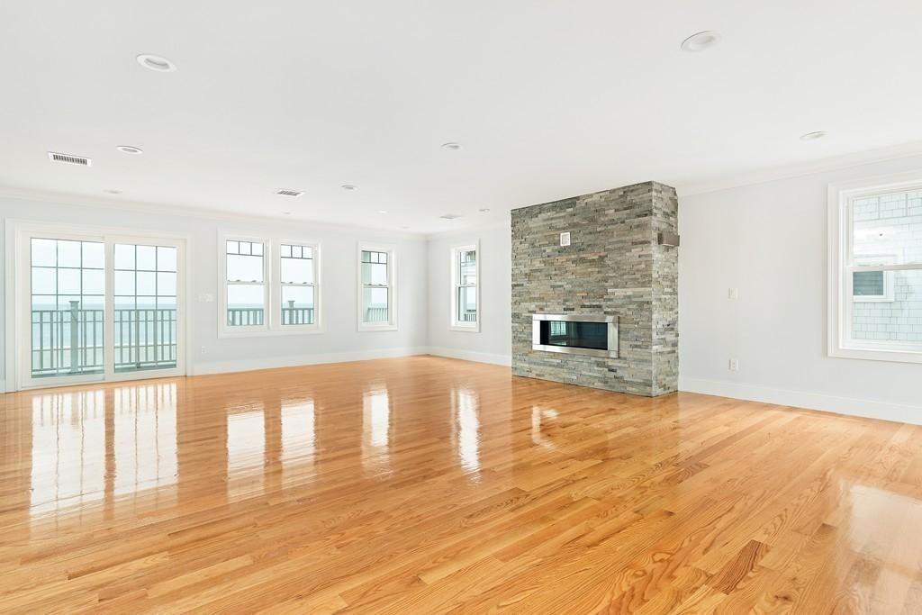 308 Ocean Street Marshfield, MA 02050 - Photo 11 of 42 an empty room with wooden floor and fireplace
