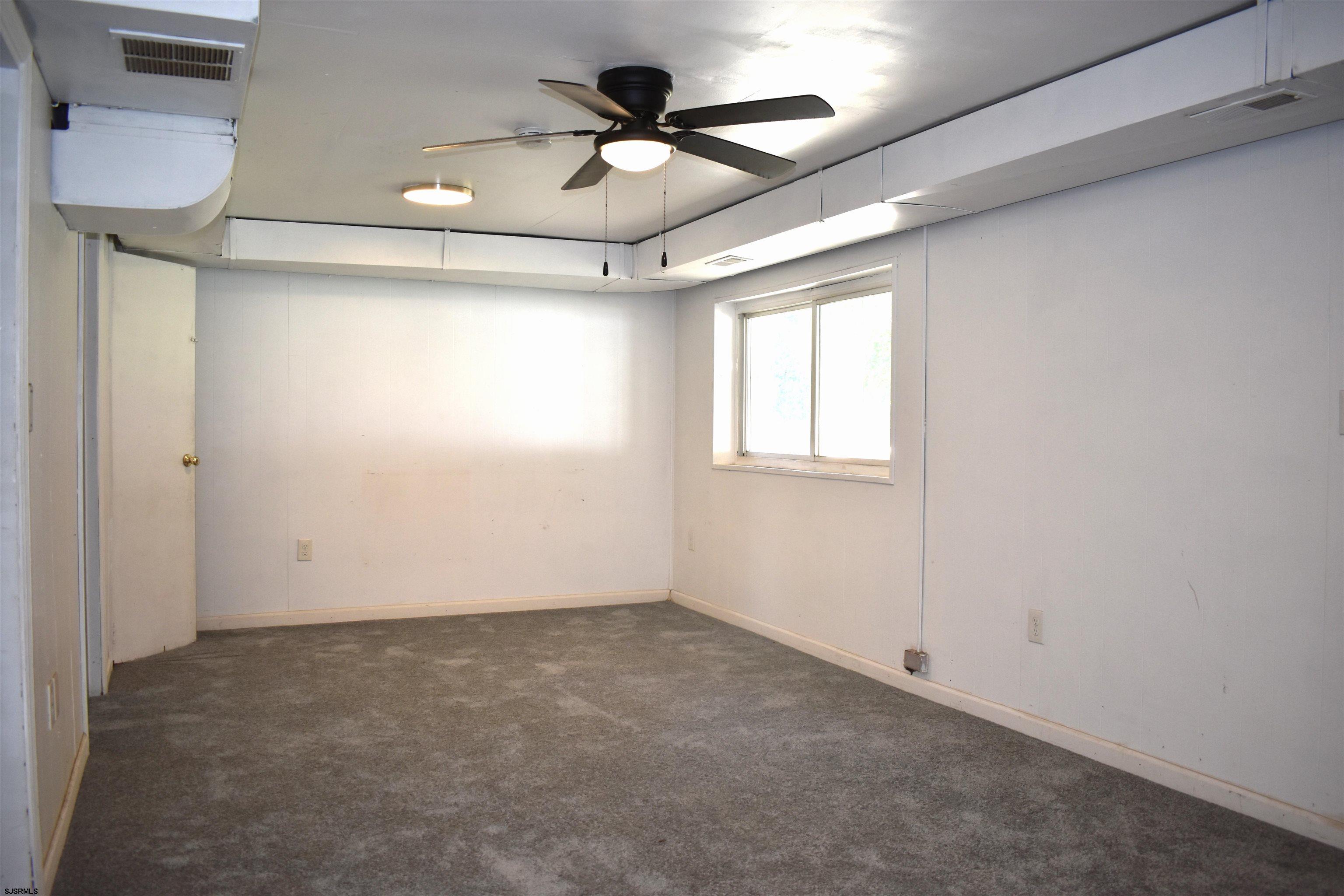 720 6th Road Newtonville, NJ 08346 - Photo 19 of 23 an empty room with a ceiling fan and window