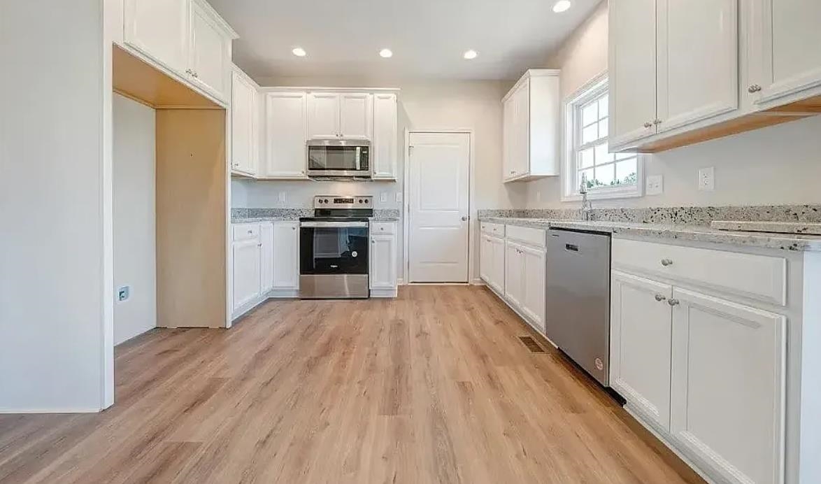 201 Winnbrook Street Staunton, VA 24401 - Photo 6 of 12 a kitchen with stainless steel appliances granite countertop a stove top oven a sink dishwasher and a refrigerator with wooden floor
