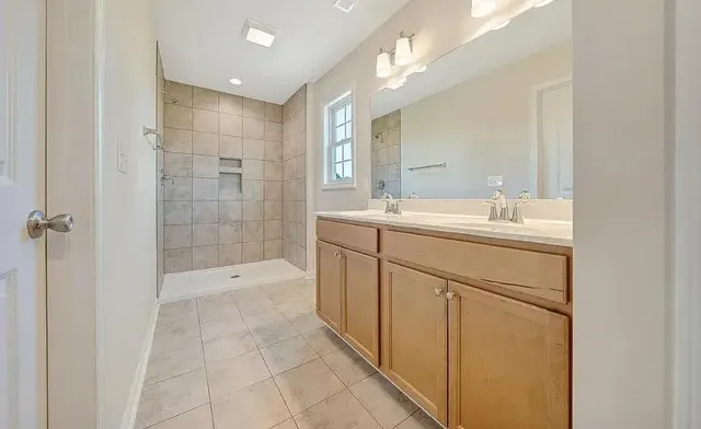 a spacious bathroom with a shower sink and mirror