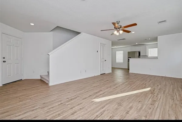 a view of a kitchen with wooden floor and a ceiling fan