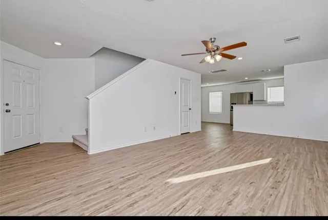 a view of a kitchen with wooden floor and a ceiling fan