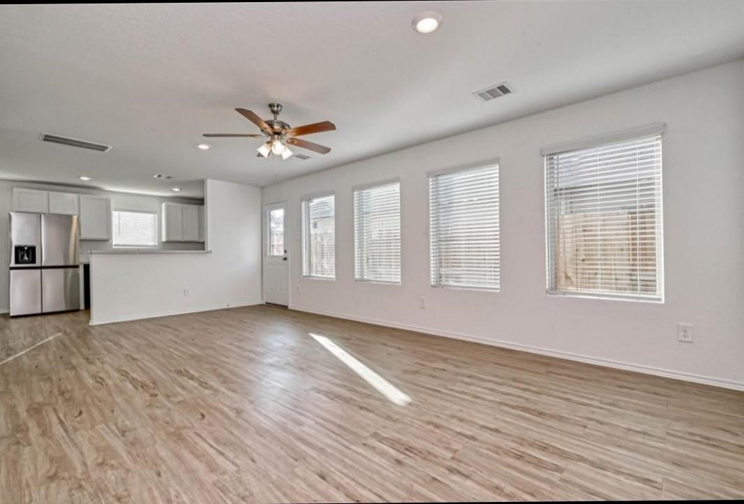 1319 Vincente Court Conroe, TX 77301 - Photo 6 of 10 a view of an empty room with window and wooden floor