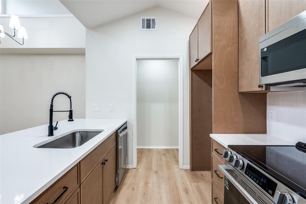 17490 Meandering Way, Unit 2202 Dallas, TX 75252 - Photo 15 of 24 Kitchen featuring light wood-finish flooring, white countertops, and wood-tone cabinetry