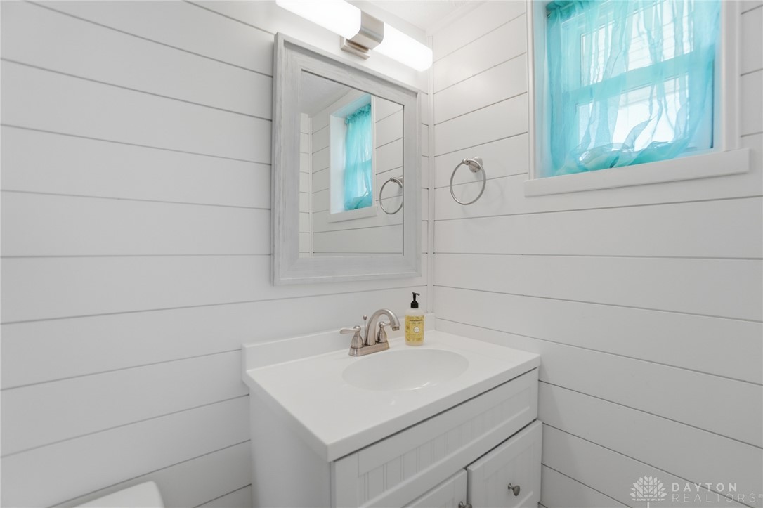 629 Storms Road Dayton, OH 45429 - Photo 43 of 51 This bright bathroom features a vanity with a white countertop and shiplap walls.