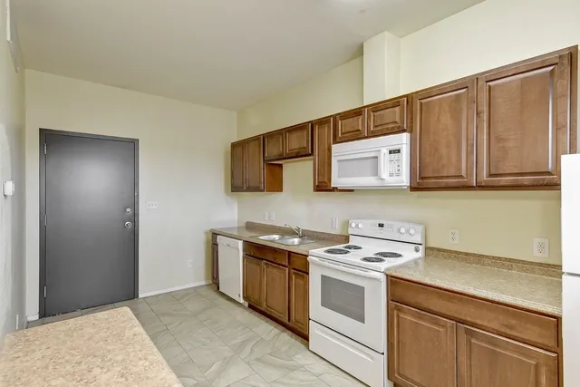 a kitchen with stainless steel appliances a stove top oven and a refrigerator