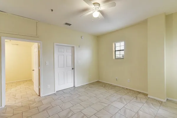 an empty room with closet and a chandelier fan