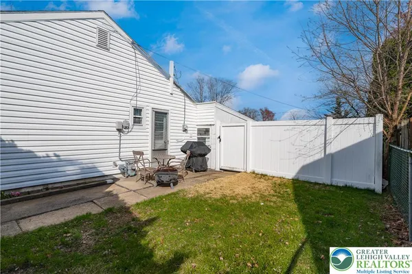 a backyard of a house with table and chairs