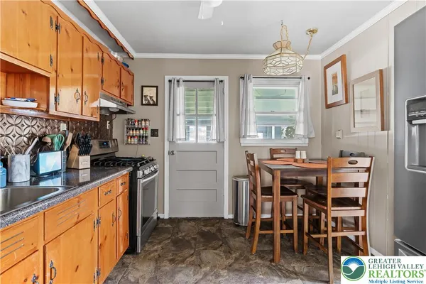 a kitchen with stainless steel appliances granite countertop a stove a sink and a refrigerator