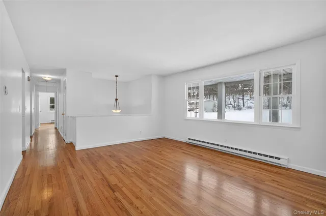 a view of empty room with wooden floor and windows