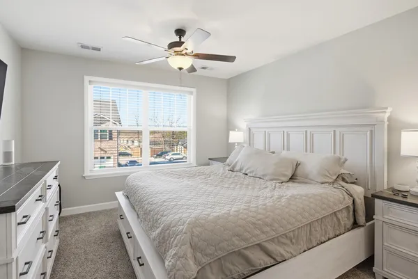 a bedroom with a large bed and a chandelier