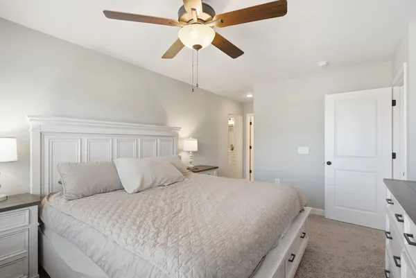 a bedroom with a bed and a ceiling fan