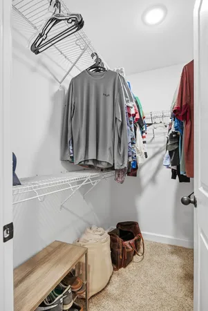 a view of walk in closet with clothes and shoes