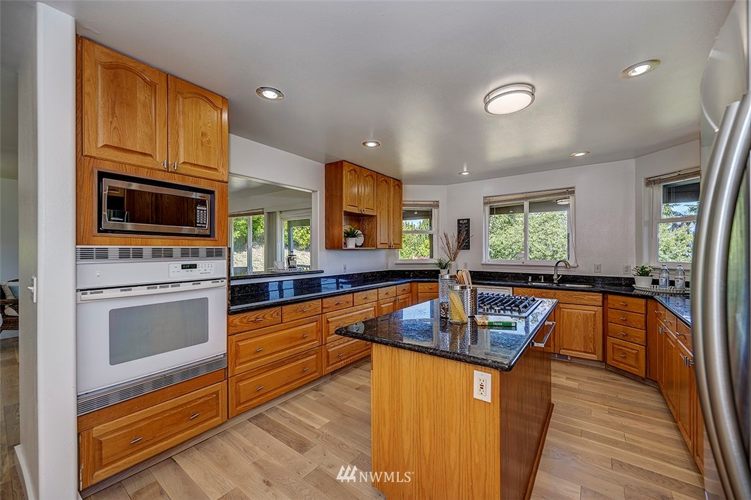 1809 Holbrook Avenue Everett, WA 98203 - Photo 14 of 40 a kitchen with stainless steel appliances granite countertop a stove top oven a sink dishwasher and microwave with wooden floor
