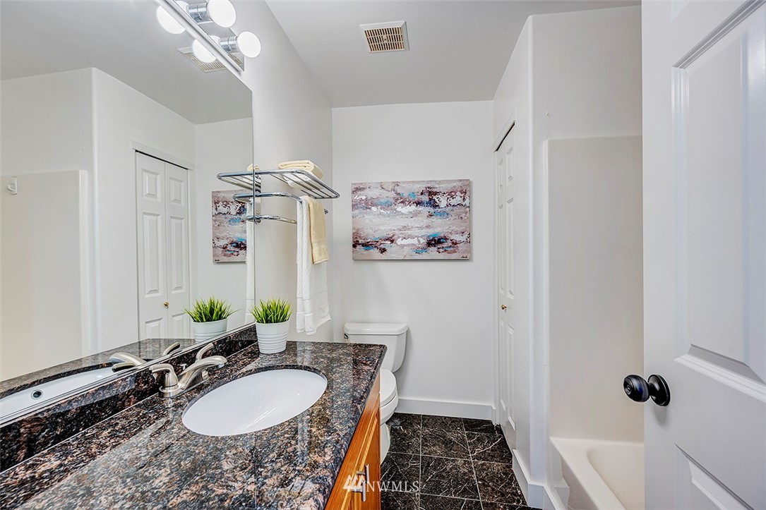 1809 Holbrook Avenue Everett, WA 98203 - Photo 26 of 40 a bathroom with a granite countertop sink a mirror a vanity and shower