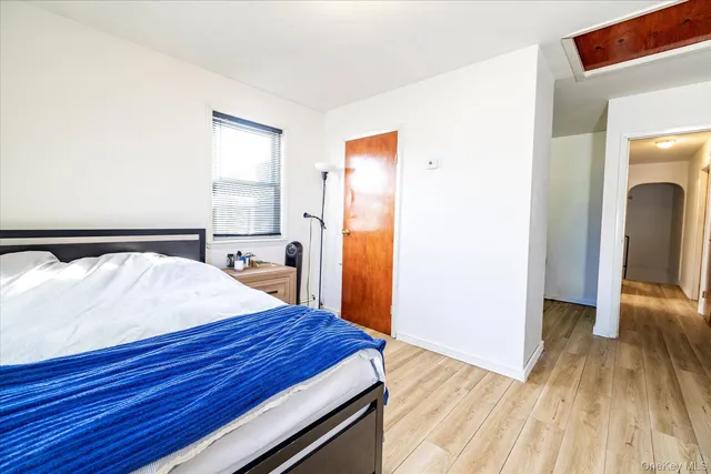 a spacious bedroom with a bed and a dresser