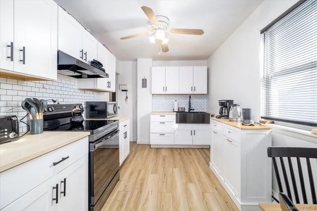 a kitchen with stainless steel appliances a stove sink microwave and cabinets