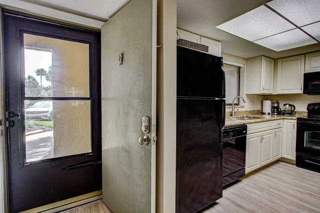a kitchen with granite countertop a stove sink and cabinets
