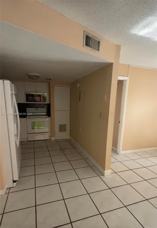 a kitchen with granite countertop a refrigerator and a stove top oven