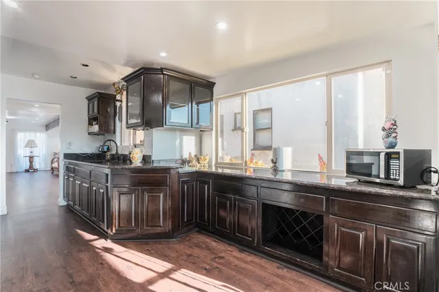 a kitchen with stainless steel appliances granite countertop a sink and wooden cabinets