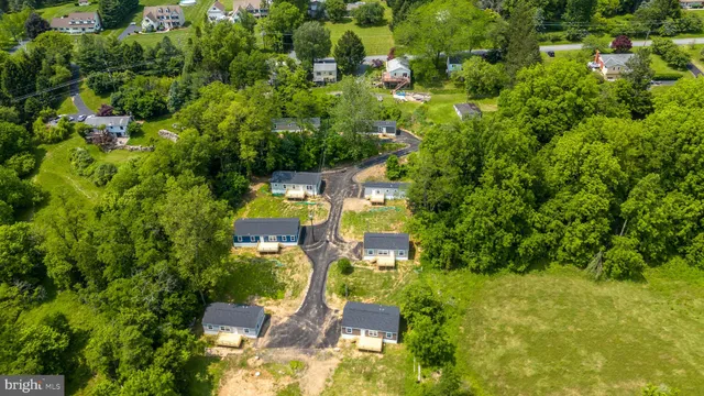 an aerial view of residential house with outdoor space and trees all around