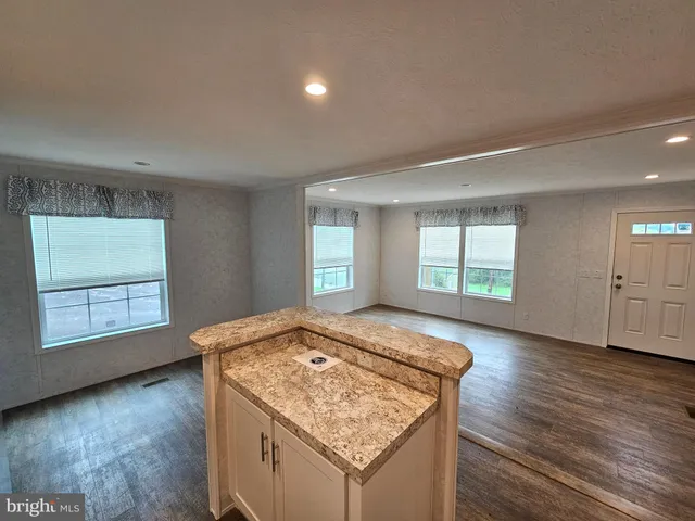 an empty room with wooden floor and window