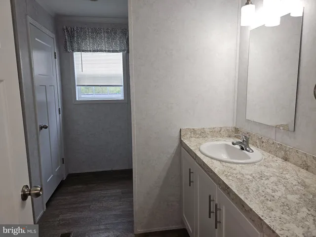 a bathroom with a granite countertop sink and a mirror