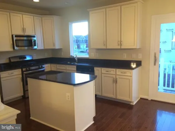 a kitchen with stainless steel appliances granite countertop a stove a refrigerator and a microwave