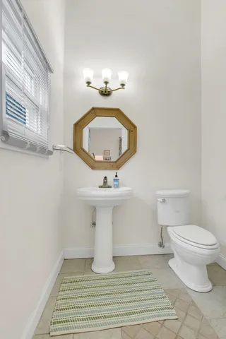 a bathroom with a sink toilet and mirror