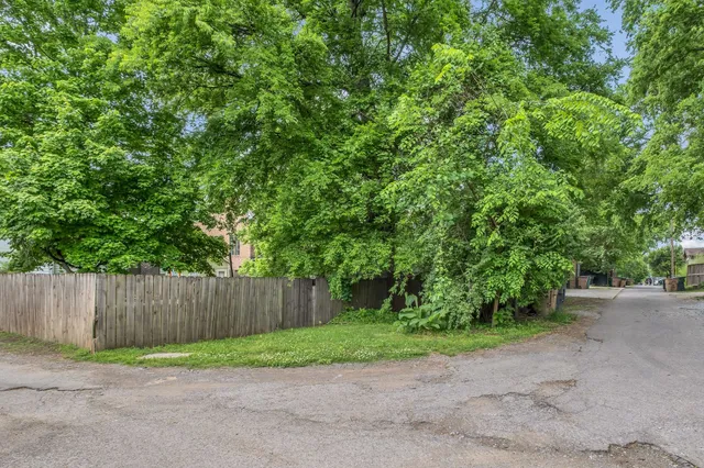 a view of backyard with wooden fence
