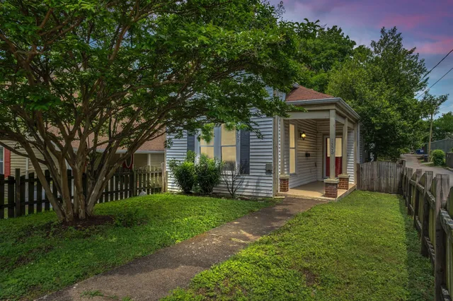 a front view of a house with yard and green space