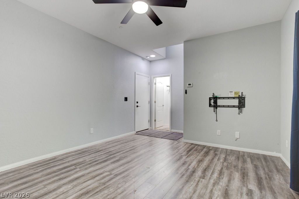 7724 Vibrant Thread Court Las Vegas, NV 89149 - Photo 4 of 43 A versatile living area with light wood-style flooring and a contemporary ceiling fan awaits your personal touch.