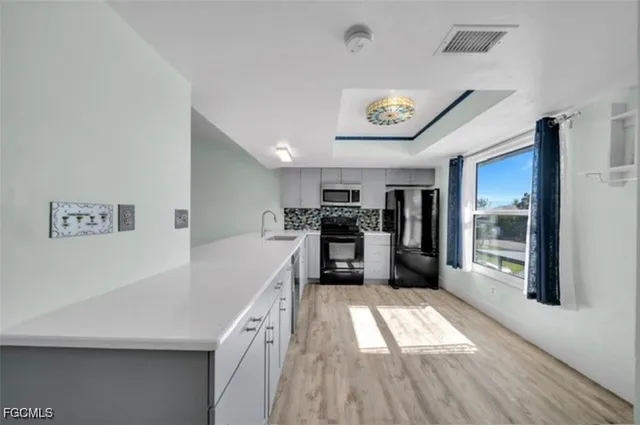 a kitchen with white cabinets and stainless steel appliances