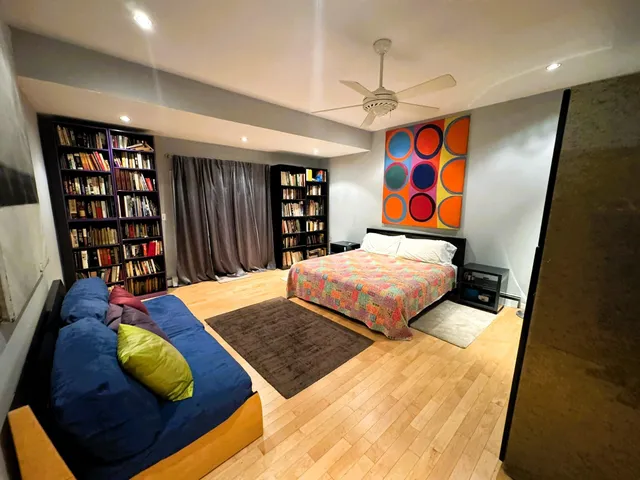 a bedroom with large bed and a book shelf