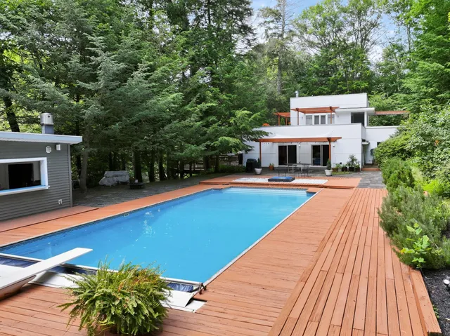 a swimming pool with outdoor seating and yard