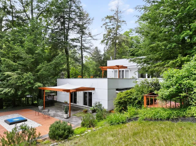 an aerial view of a house with swimming pool next to a big yard
