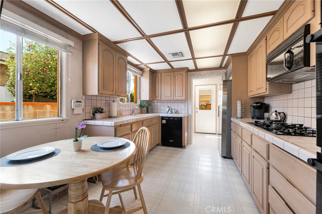 630 Uclan Drive Burbank, CA 91504 - Photo 12 of 41 a kitchen with stainless steel appliances granite countertop a sink a stove a refrigerator cabinets dining table and chairs