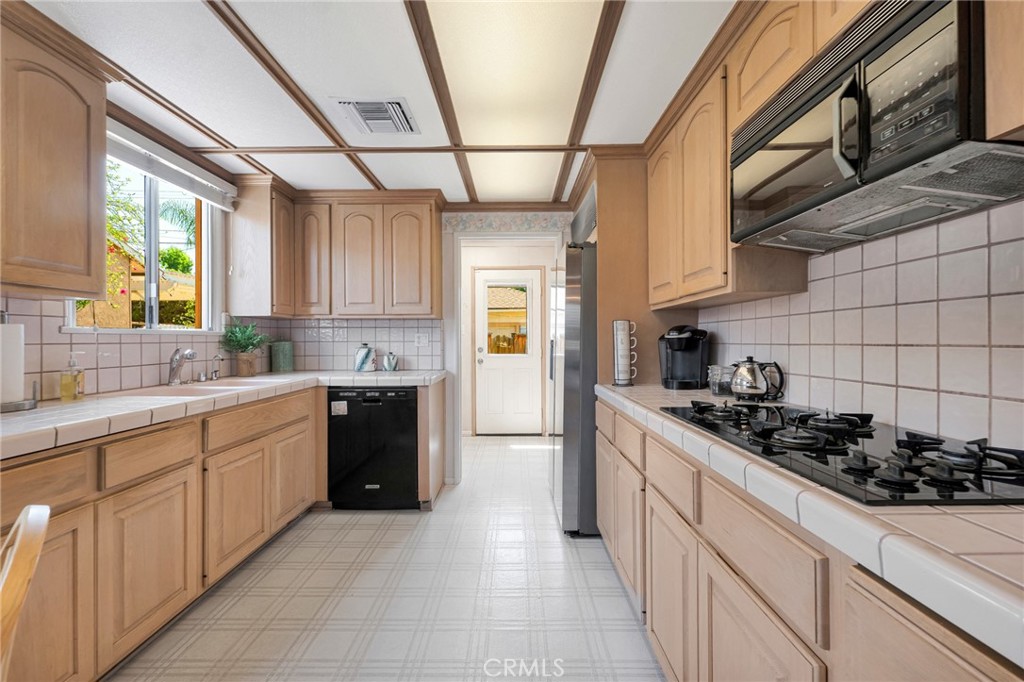 630 Uclan Drive Burbank, CA 91504 - Photo 13 of 41 a kitchen with stainless steel appliances a sink stove and cabinets