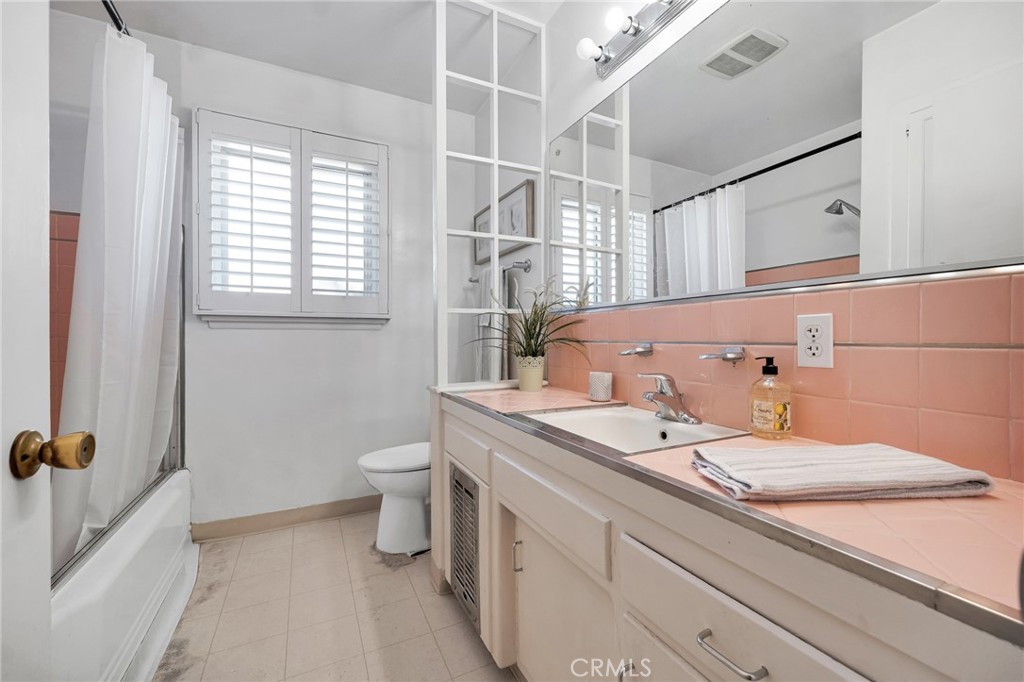 630 Uclan Drive Burbank, CA 91504 - Photo 20 of 41 a bathroom with a granite countertop sink a toilet and a mirror