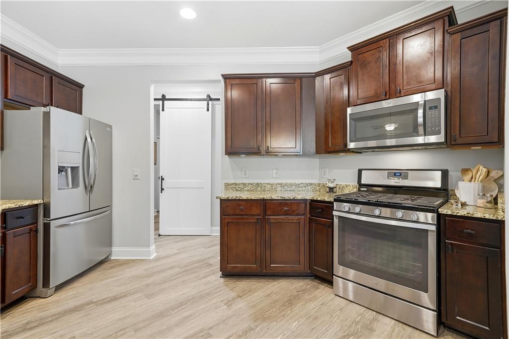 302 Spence Circle Ball Ground, GA 30107 - Photo 14 of 55 a kitchen with granite countertop wooden cabinets a stainless steel appliances and a counter space