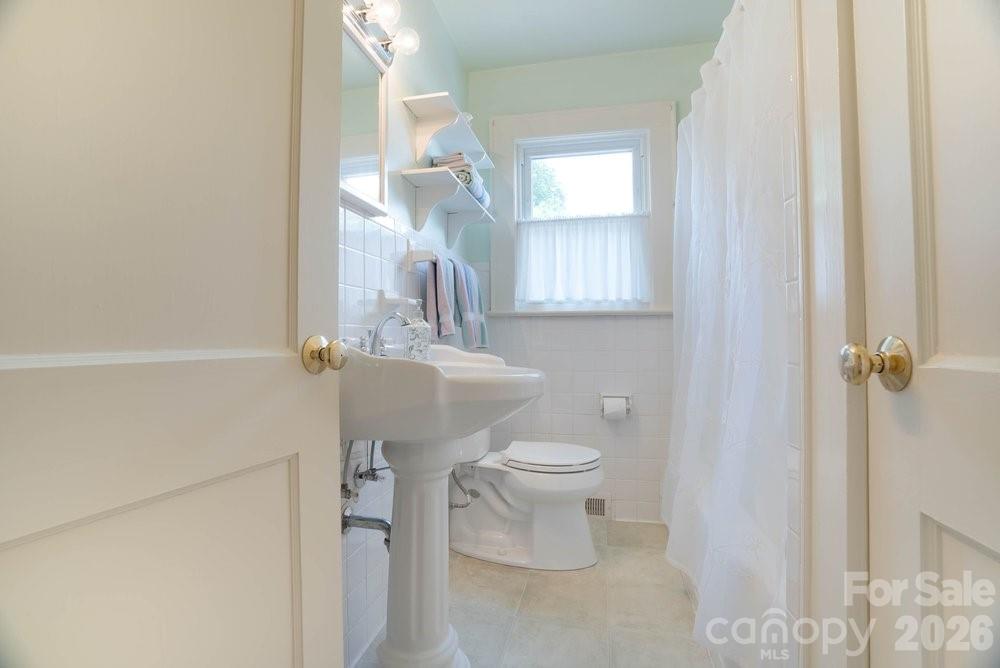 124 Rumple Street Troutman, NC 28166 - Photo 19 of 42 a bathroom with a toilet a sink and mirror