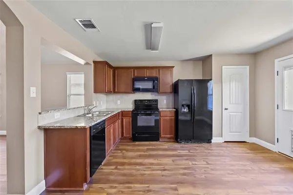 a kitchen with granite countertop stainless steel appliances and wooden cabinets