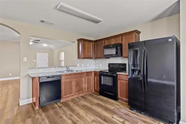 a kitchen with granite countertop stainless steel appliances and wooden cabinets