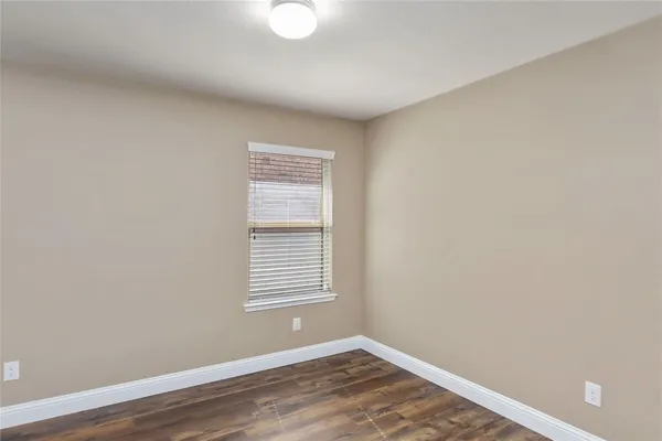 a view of a room with wooden floor and a window
