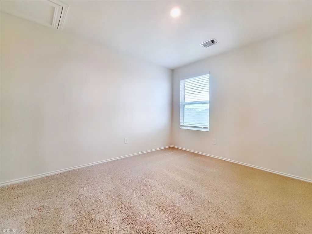 419 Sickle Loop Kyle, TX 78640 - Photo 24 of 35 A well-lit bedroom offering a neutral palette and plush carpeting.